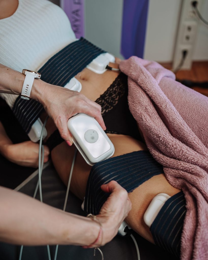 Eine Frau wird von einer anderen Frau massiert, was eine ruhige Atmosphäre unterstreicht, in der Entspannung und Selbstfürsorge im Mittelpunkt stehen.